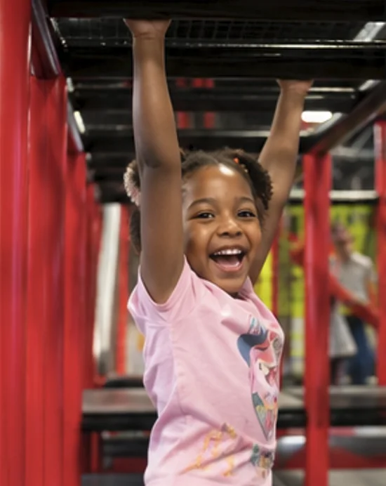 Child laughing on the monkey bars in the indoor playground